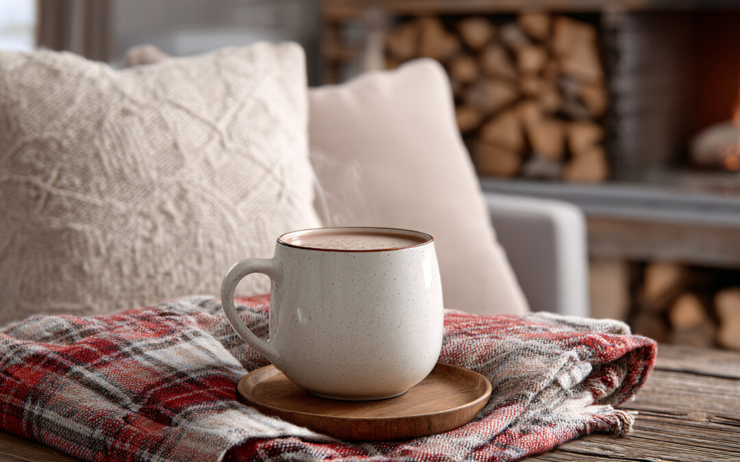 Cozy Warmth by the Fireplace: A steaming mug of hot beverage rests invitingly on a plaid blanket, nestled amidst plush pillows on a comfortable sofa, with a crackling fireplace providing a warm.